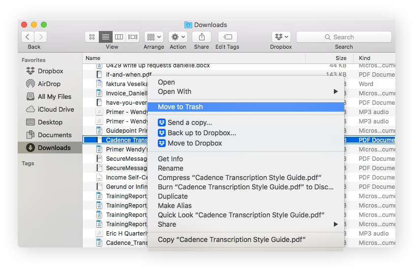 The Downloads window, with a document selected and "Move to Trash" selected in the actions menu.