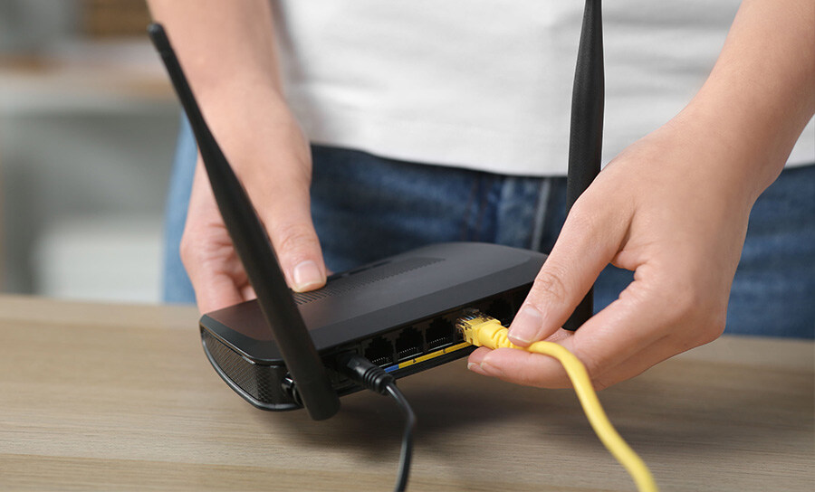 Image montrant un câble Ethernet branché sur un routeur pour configurer un réseau local sans fil.